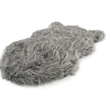 A full view of a furry charcoal grey colored curved dog bed