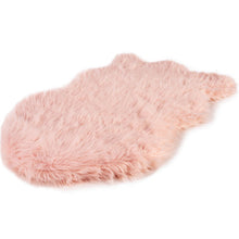 A full view of a curved blush pink furry dog bed