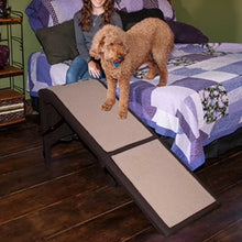 a fluffy brown going down the bed through a chocolate Pet Gear extra Wide Dog Ramp with Supertrax with a woman sitting on the bed next to him