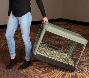 a woman dragging a sage colored steel dog crate on the floor with modern design