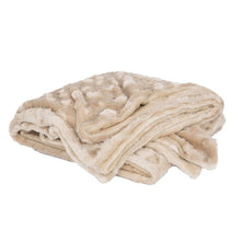 a folded cream colored velvet blanket