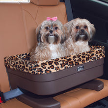 close up image of two shih-tzu inside a brown dog bucket seat in a leather car seat