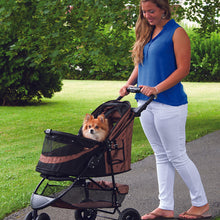 a woman walking her dog in a chocolate colored dog stroller in the park