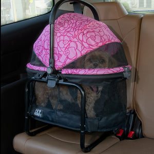 a pink floral designed dog carrier tucked in the backseat of the car