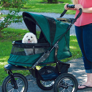 a close up image of a woman walking her dog on a pine green dog stroller in the park