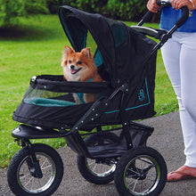 a close up image of a woman walking her  tiny dog inside a green stroller