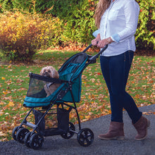 a woman walking her dog in the park in a green dog stroller