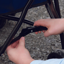 a hand of a woman fixing a black leg frames of a dog stroller