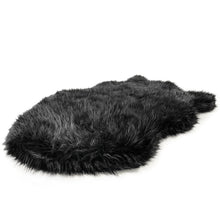 a black fluffy dog bed with white background 