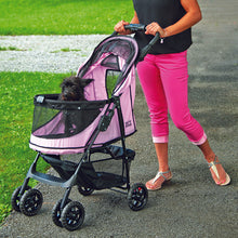 a woman walking her tiny dog inside a pink dog stroller in the park
