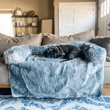 a pug sleeping on a brown couch in a grey couch lounger in a modern living room  near a white door and steel shelf