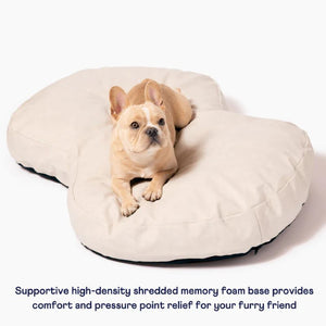 a french bulldog laying on top of a cream colored  dog bed 