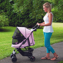 a woman walking her tiny dog inside a pink dog stroller in the park