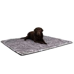 a black labrador laying on a grey and white fluffy dog blanket with white background