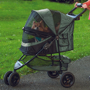 a woman walking her dog in a sage colored dog stroller in the park