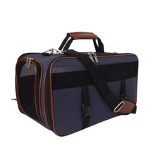 a side view image of a denim dog carrier with brown accents and handle