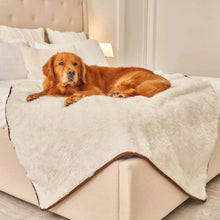 a golden retirever laying at the edge of the bed on a white dog blanket in an all white bedroom