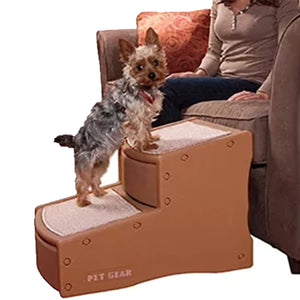a fluffy tiny dog standing on a tan two step dog stair next to a woman sitting on a brown couch