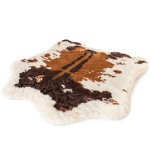 a full view image of a fluffy dog bed with brown cowhide prints
