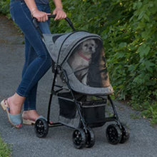 a woman walking her dog inside a grey stroller in the park