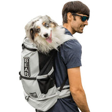 a man wearing sun glasses carrying his dog on his back inside a white dog backpack carrier with side pockets