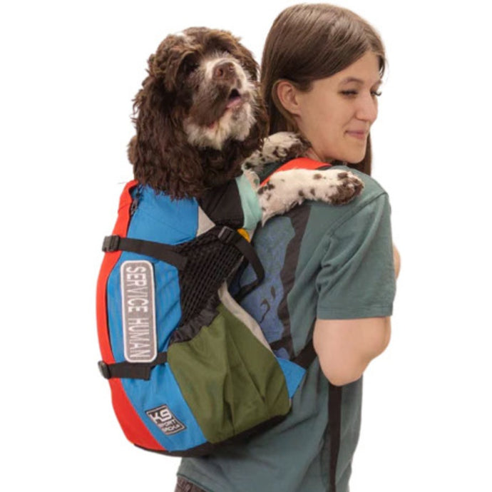 a lady in grey carrying her cute dog inside a muti colored dog backpack with side pockets