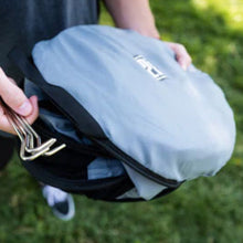 a man holding a blue round bag ang a set of steel tent lock