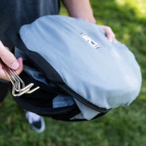 a man holding a blue round bag ang a set of steel tent lock