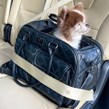 a tiny fluffy dog inside a black leather dog carrier at the back seat of a car with seatbelts on 