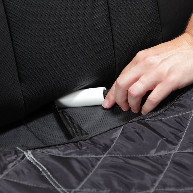 A picture of a hand on a car seat pulling of a white handled safety strap 