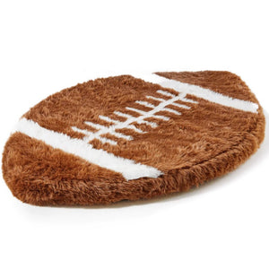 A full view of a furry football shaped dog bed 