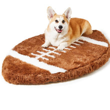 A corgi laying on a furry football shaped dog bed 