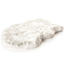 A full view of a furry curved white orthopedic dog bed 