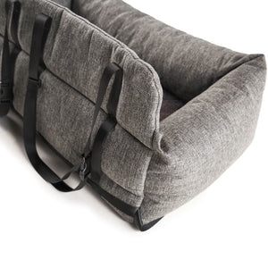 A back view of a grey dog bed with safety straps on it 