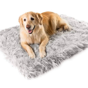 A golden retriever laying on a rectangular grey dog bed 