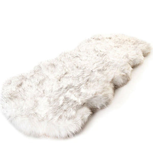 A full view of a curved furry white dog bed 