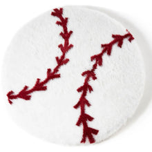 top view of a furry round white baseball shaped dog bed