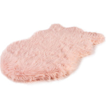 A full view of a curved blush pink furry dog bed 