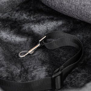 A picture of a jis type bow shackle safety lock on a black strap on a grey dog bed 