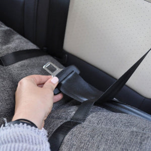 A picture of a car seatbelt lock being held by a lady's hand