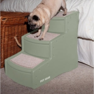 A close up image of a pug getting of bed through a three step dog stairs sage colored next to a basket 