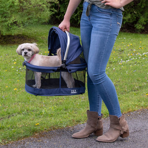 A lady walking outdoors carrying her dog on a Midnight River View 360 Carrier