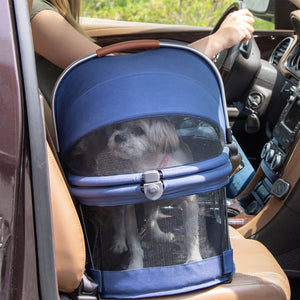 a close up image of a dog inside a Midnight River View 360 Carrier next to her owner driving the car