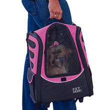a woman carrying her dog inside a pink dog carrier