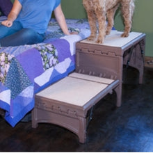 a close up image of a foldable ramp with a furry dog standing on it next to a lady in blue in the bed 