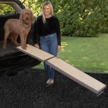 a lady in black watching her dog get off the car through a brown free standing ramp with extra panel 
