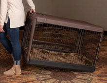 a woman dragging a large brown steel dog crate on the floor with modern design