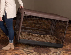 a woman dragging a large brown steel dog crate on the floor with modern design