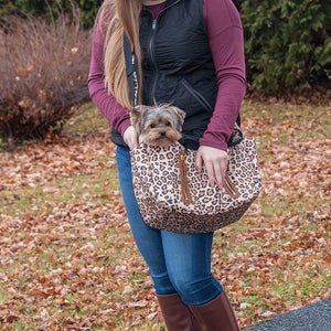 a lady in white carrying her dog outdoors on a Sling Pet Carrier Purse, jaguar