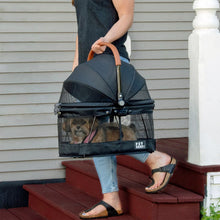a woman carrying down the stairs inside a balck dog carrier